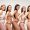 five smiling multiethnic women in lingerie posing with hands on hips isolated on grey, body
